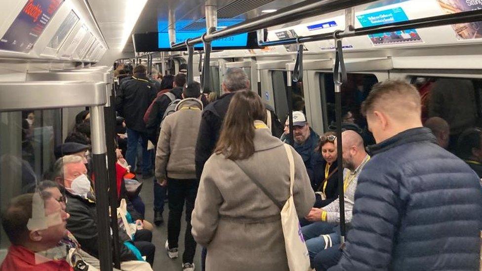 People on a Crossrail train as it goes through a tunnel