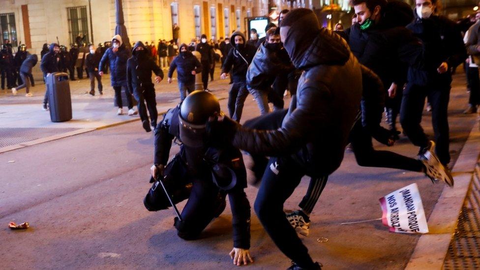 Demonstrators kick a police officer as supporters of Catalan rapper Pablo Hasél protest against his arrest in Madrid, Spain