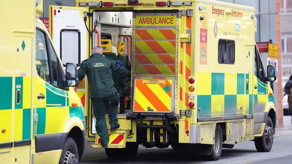 A paramedic gets into the back of an ambulance