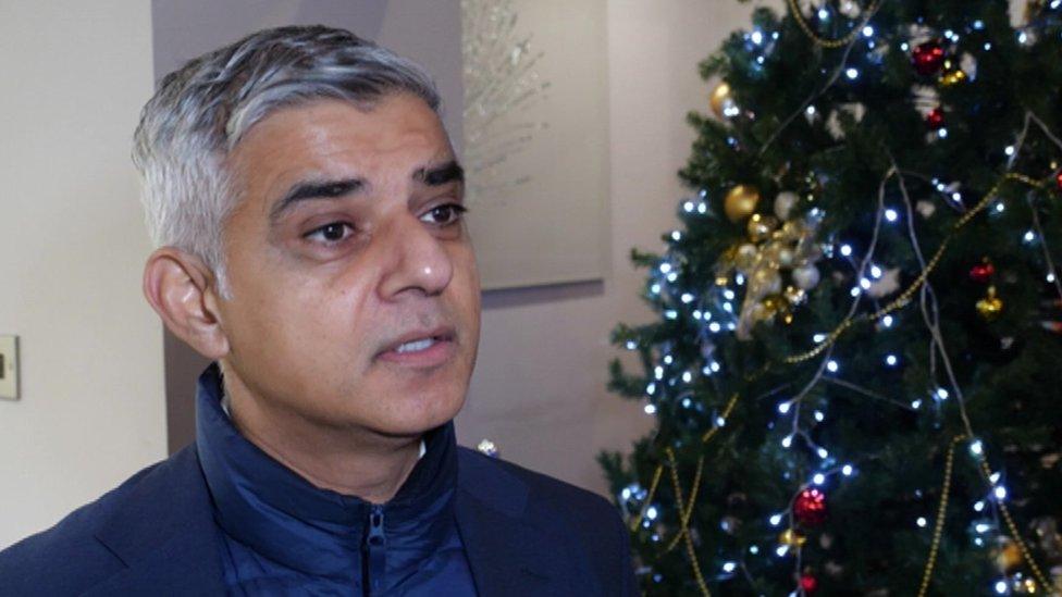 Sadiq Khan speaking in front of a Christmas tree.