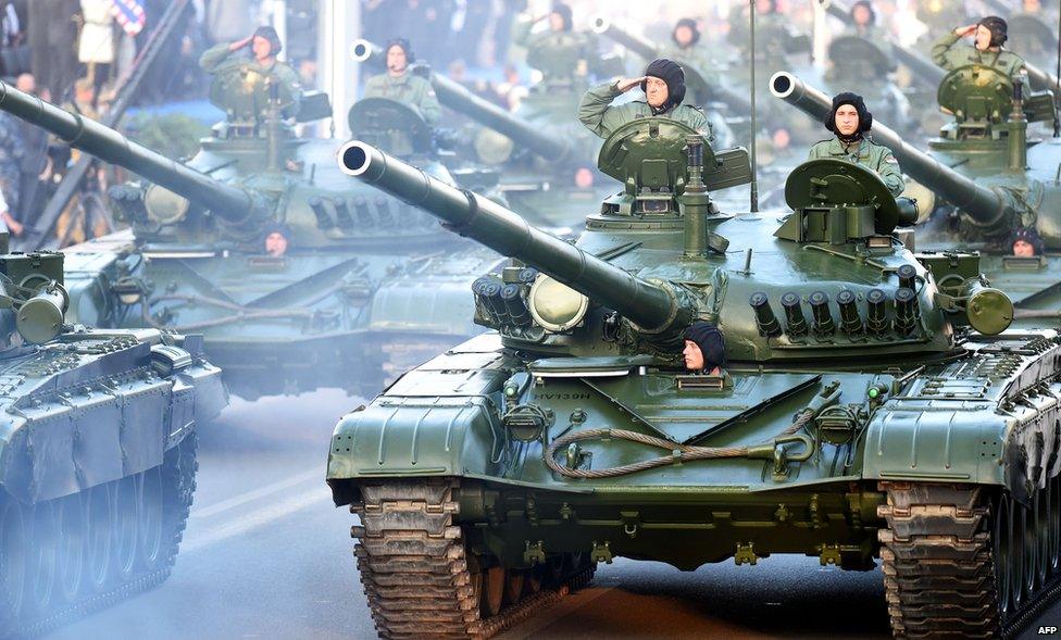 Croatian soldiers salute on top of armoured vehicles on August 4, 2015 in Zagreb, during a military parade to mark the 20th anniversary of Operation Storm