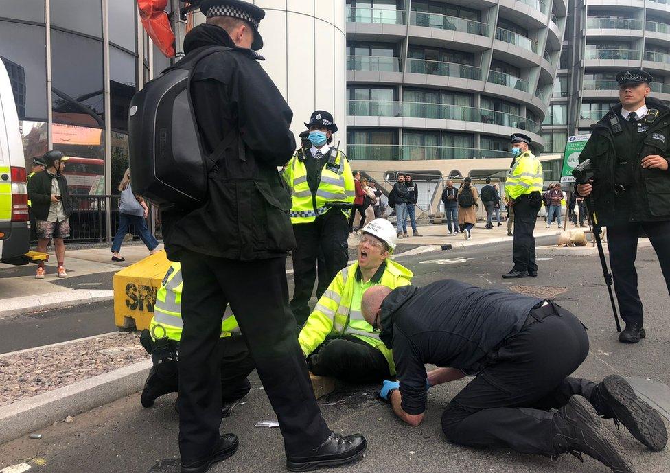 Protester's glued hand being removed