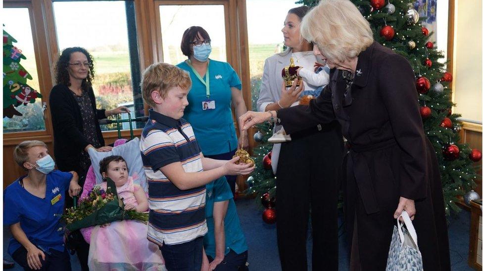 The Queen handing out gifts to children at the hospice