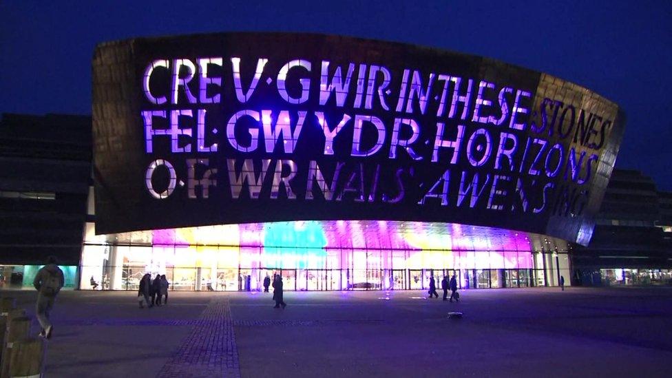 The front of the Wales Millennium Centre lit up purple