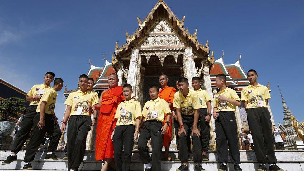 Members of Wild Boar youth soccer team and their coach-turned-Buddhist monk Ekapol Chantawong (back, C) visit Wat Phra Kaew or Temple of the Emerald Buddha within the Grand Palace complex in Bangkok, Thailand,