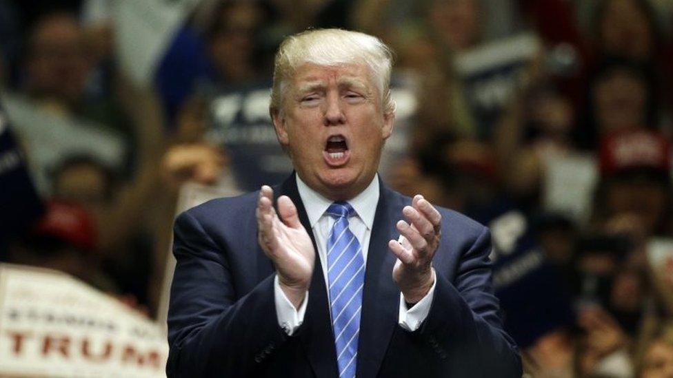 Republican presidential candidate Donald Trump applauds after singing the National Anthem during a rally at the Anaheim Convention Center (25 May 2016)