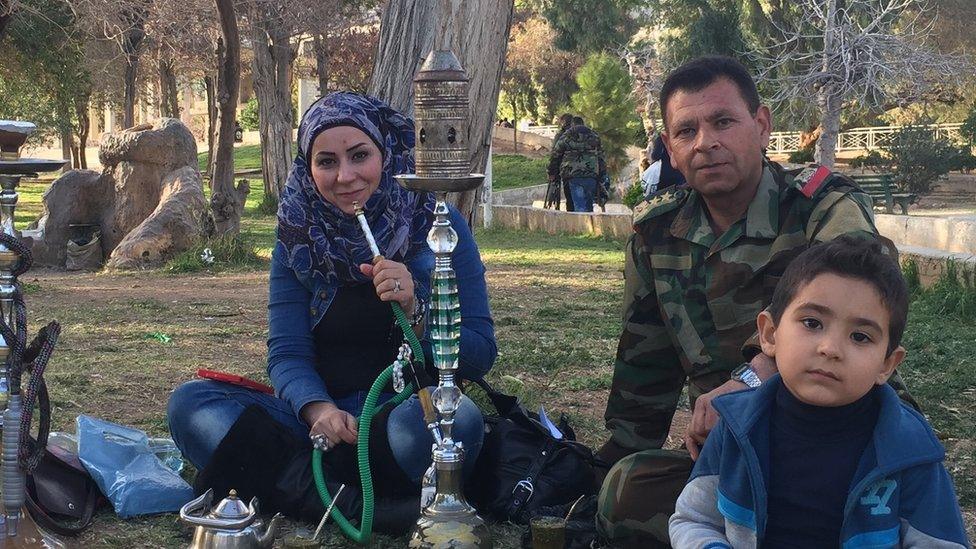 A Syrian family relax in a park in Damascus