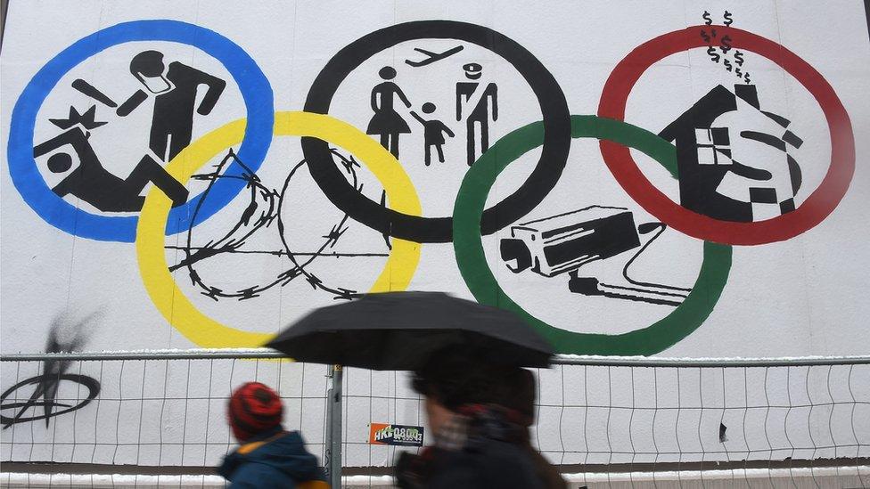 A picture made available on 23 November 2015 shows passersby walking past a poster with the Olympic rings on the Rota Flora theatre in Hamburg, Germany, 22 November 2015.