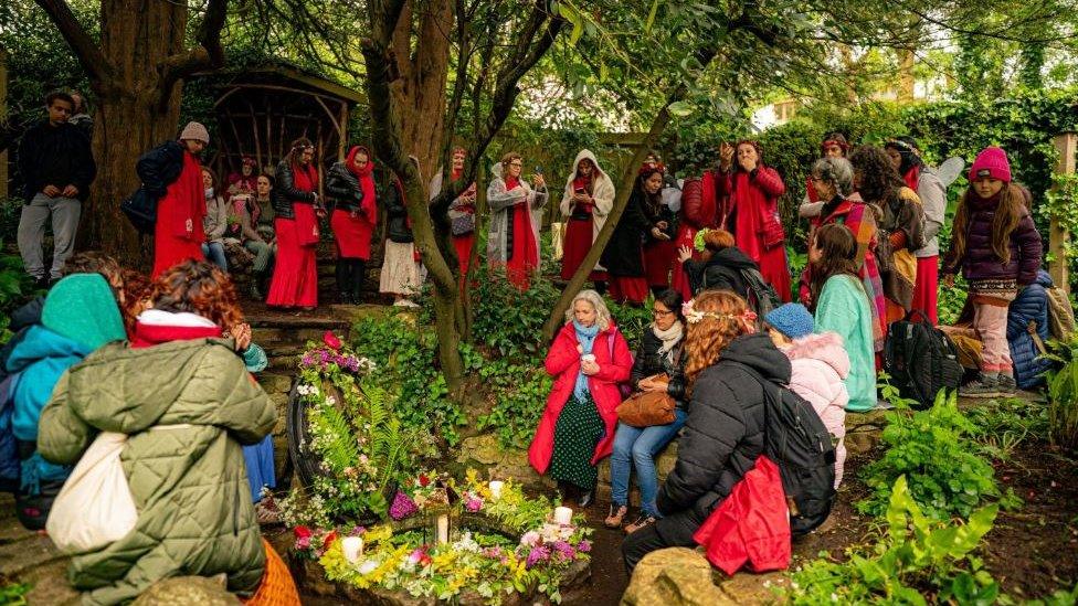 A group of people in bright clothes sitting