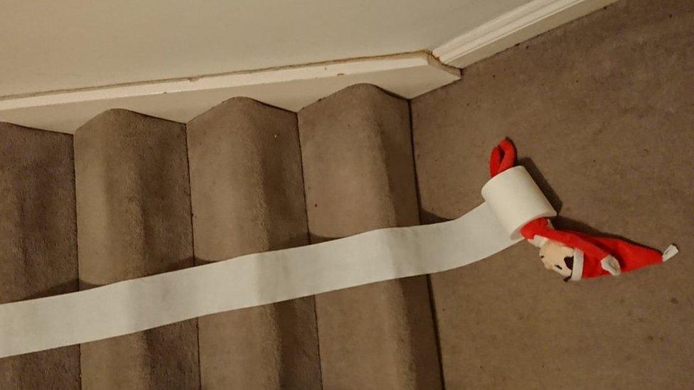 An elf rolled up in loo roll