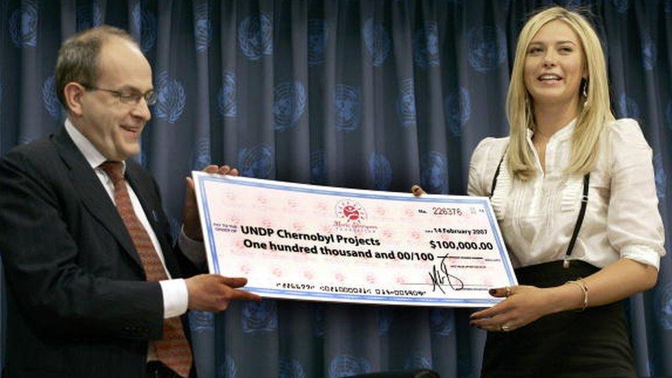 Maria Sharapova gives a check for $100,000 to UN Under-Secretary General Ad Melkert at the UN headquarters