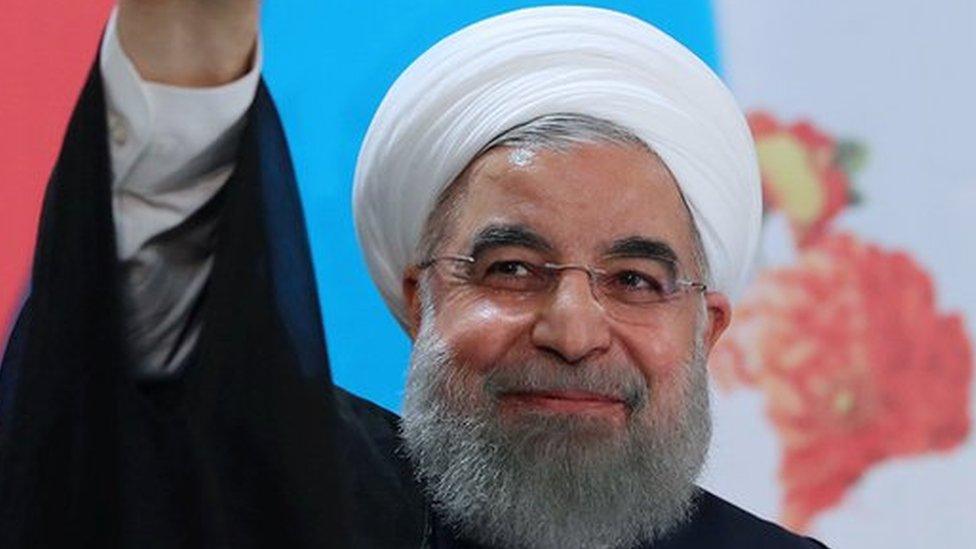 Hassan Rouhani holding up fingers covered in ink