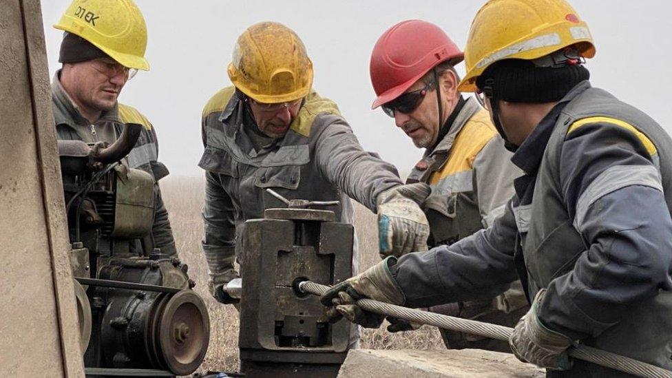 Four men in hard hats working