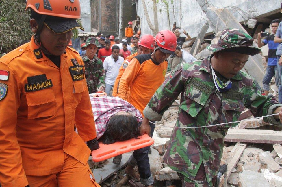 Indonesian rescue workers carry a survivor from a fallen building after an earthquake in Ulee Glee, Pidie Jaya, in the northern province of Aceh, Indonesia 7 December 2016.