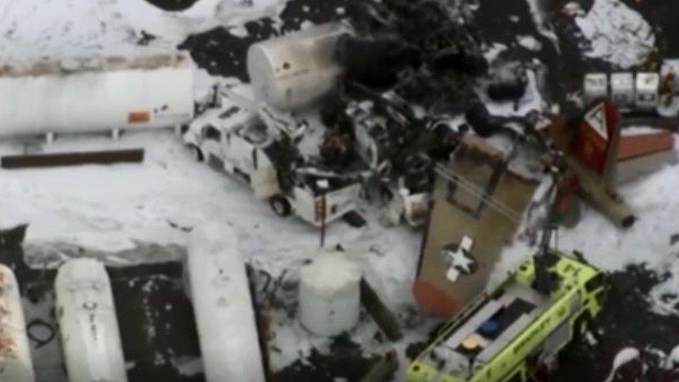 A plane wing is seen among the wreckage