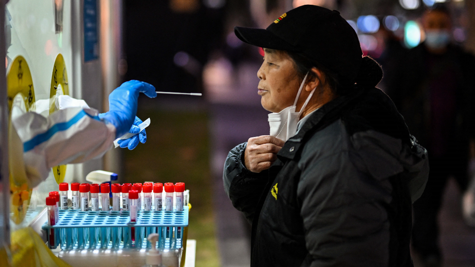 A health worker takes a swab sample from a woman to test for the Covid-19 coronavirus in the Huangpu district in Shanghai