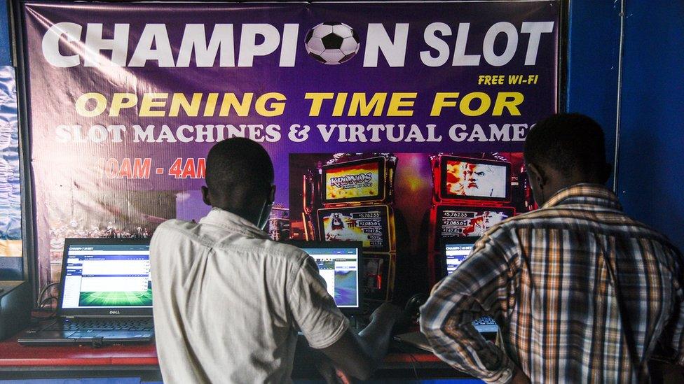 Men gambling in betting shop in Uganda