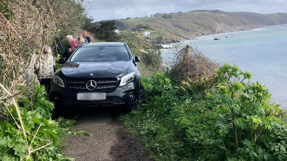 Black Mercedes car blocking cliff path