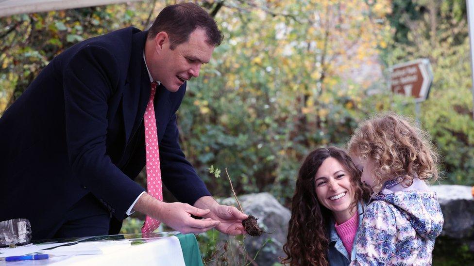 Welsh government Deputy Minister for Climate Change Lee Waters hands over a sapling to one family