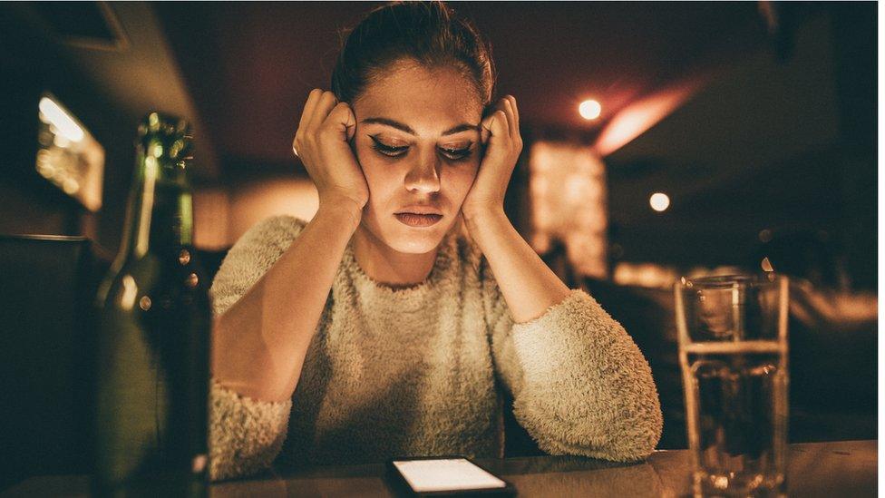 Stock image of a woman staring at her phone