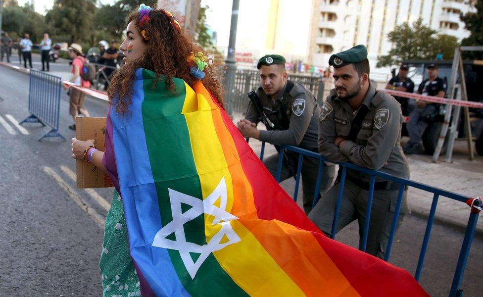 A woman in Israel with the rainbow flag and Star of David