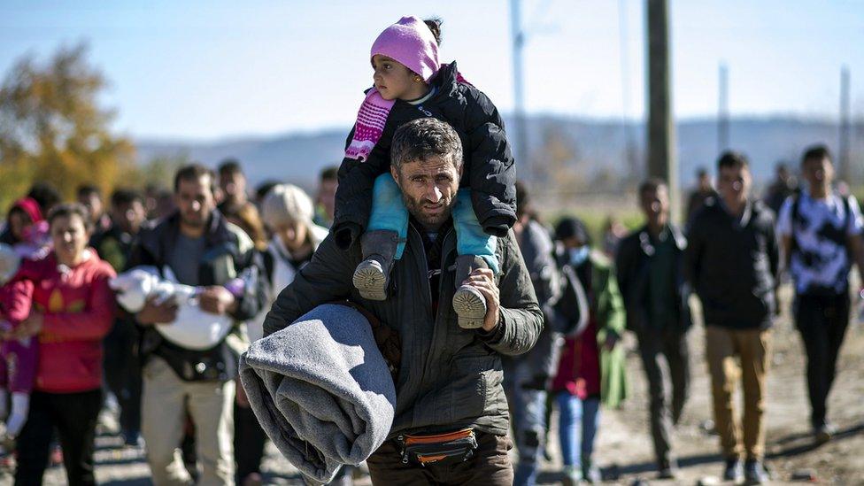 Migrants and refugees cross the Greek-Macedonian border on November 13, 2015