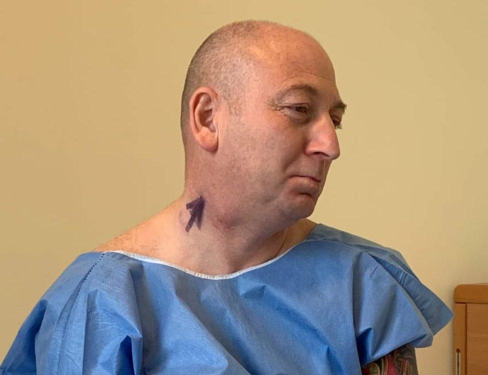 Martin before the operation with an arrow written on his neck next to a visible lump