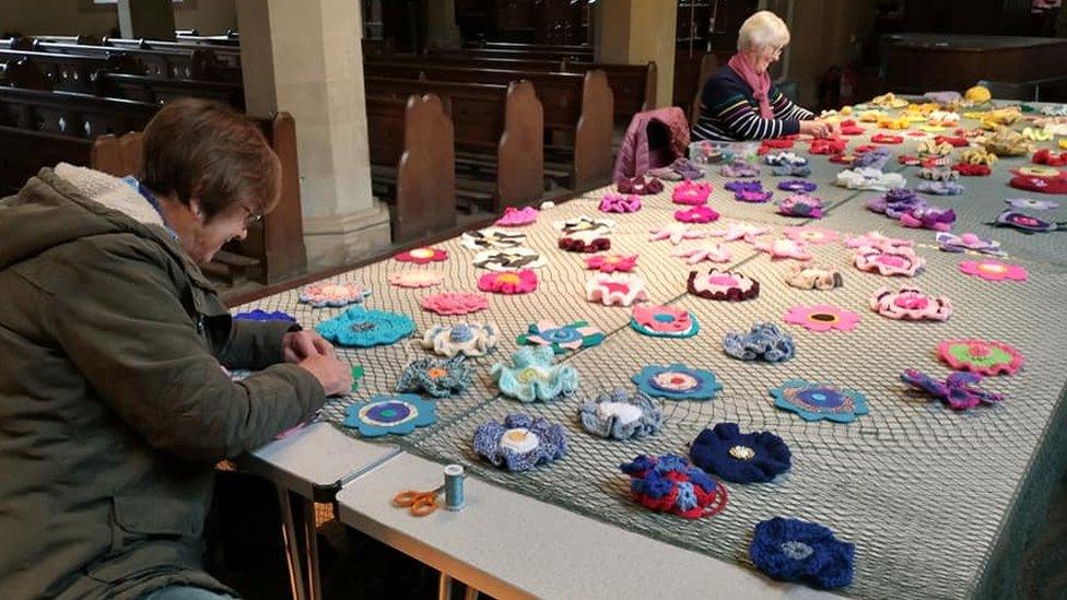 Women sewing flowers in a church