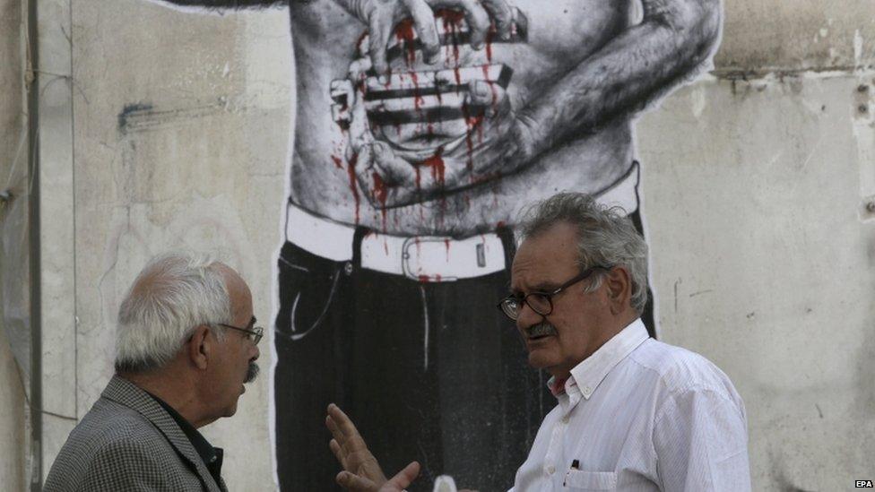 Greeks talk in front of bleeding euro sign