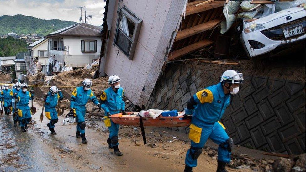 Police arrive to clear debris scattered on a street in a flood-hit area in Japan's Hiroshima prefecture9 July 2018