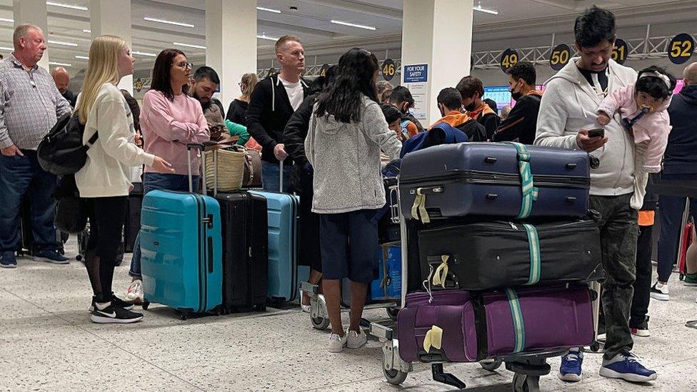 Passengers queue for check in at Manchester Airport's terminal 1 on 4 April