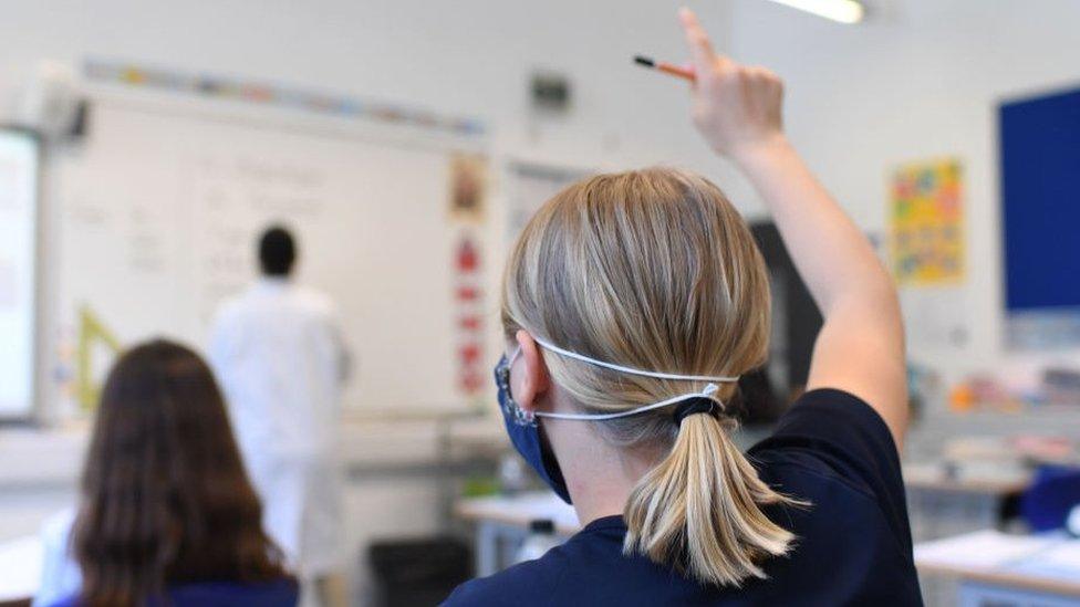 A pupil raises her hand at a school in England