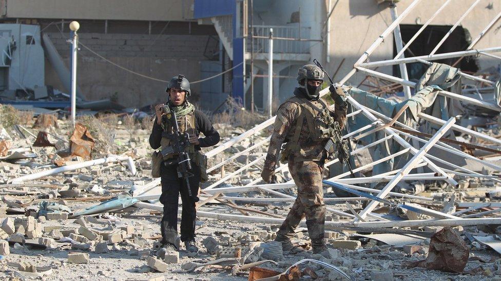 Members of Iraq's elite counter-terrorism service walk amidst debris in Ramadi