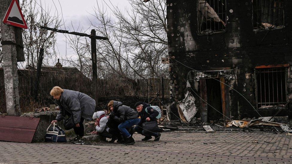 People take cover from shelling in the city of Bucha