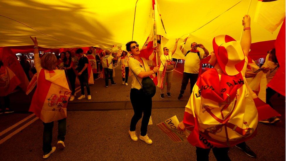 Supporters of Spanish unity walk under a large Spanish flag during a demonstration to call for co-existence in Catalonia and an end to separatism, in Barcelona, Spain, October 27, 2019