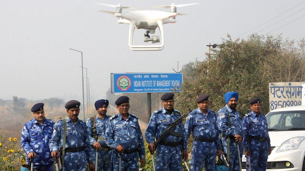 Police stand guard with a hovering drone near a jail where Indian guru and convicted murderer Gurmeet Ram Rahim Singh was being held