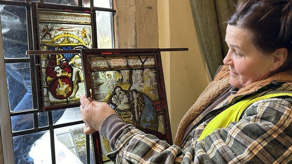 woman holding stained glass window pane