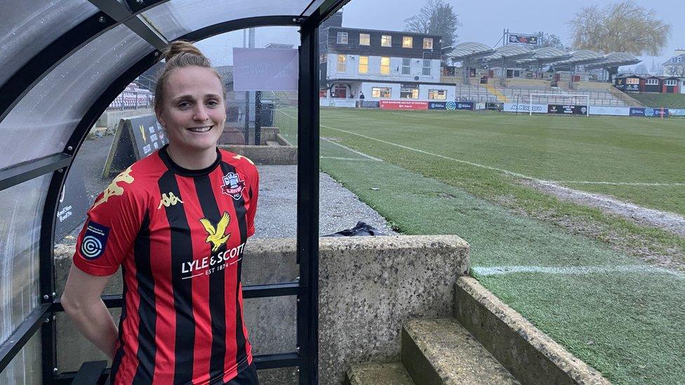 Sarah Kempton standing in the dugout at Lewes FC