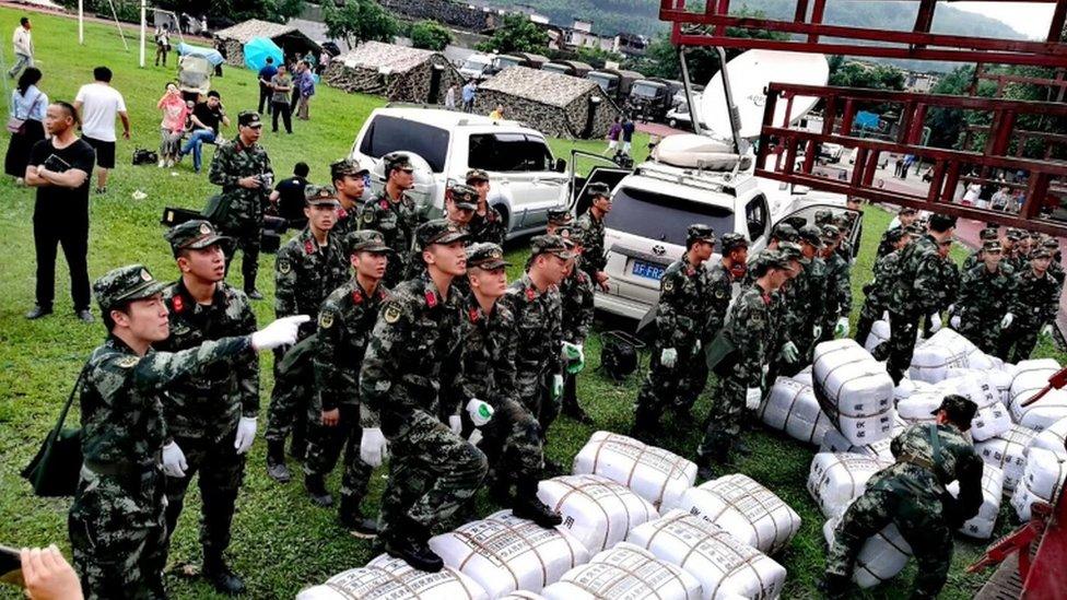 Paramilitary police unload disaster relief packages from a truck at a temporary settlement after the earthquake in Changning county, Sichuan province, China, 18 June 2019