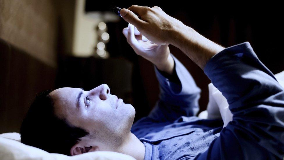 Man in bed using phone