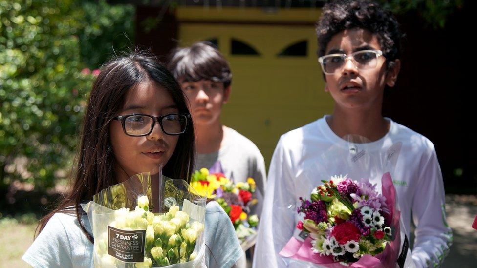 Siblings hold flowers