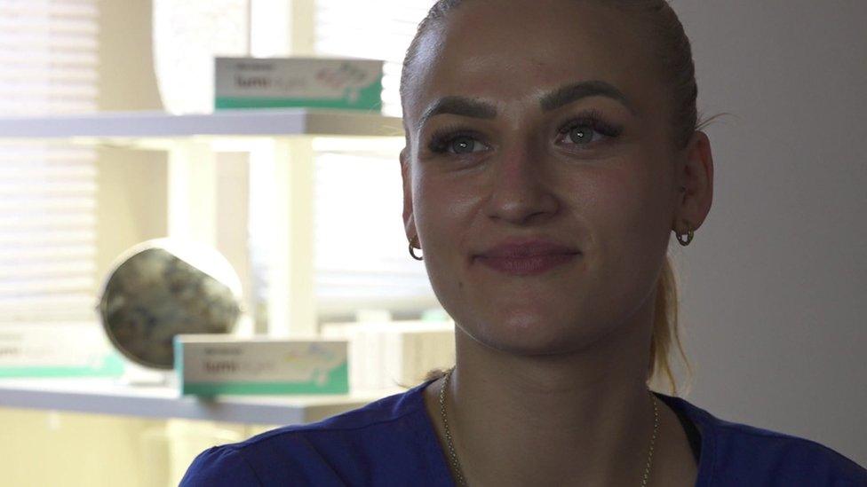 Zuzi Kam, a woman with ginger hair in a ponytail, sits inside a treatment room at So Me Beauty