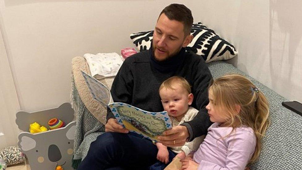 Adam reading a book to his two children