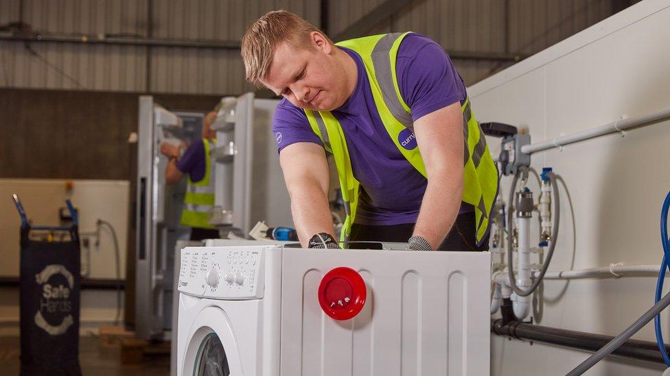 Currys worker fixing washing machine