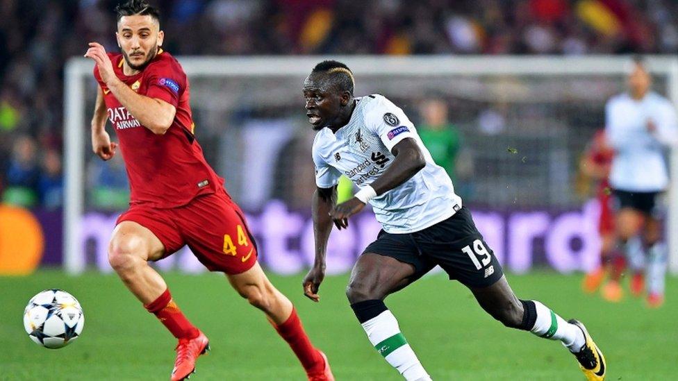 Roma and Liverpool players race for the ball