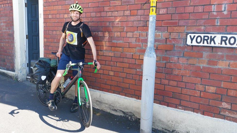 Man on a stationary bike opposite a brick wall