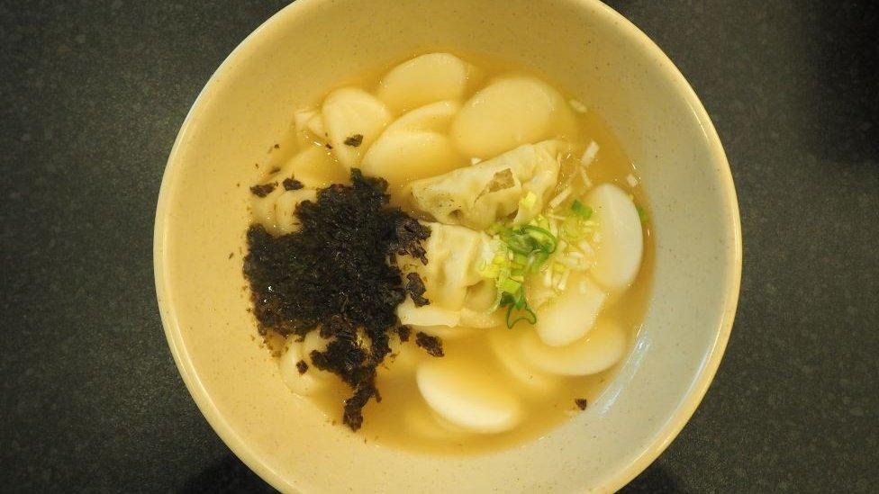 Tteokguk - a Korean soup dish typically eaten during Lunar New Year in South Korea that is made using thinly sliced rice cakes and broth.