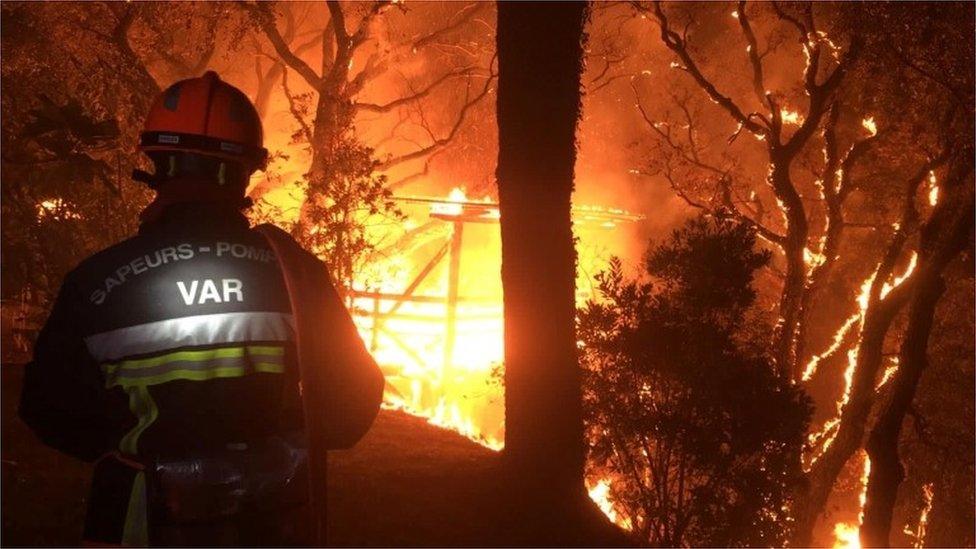 A firefighter works near at the site of a wildfire that broke out in the Var region of southern France