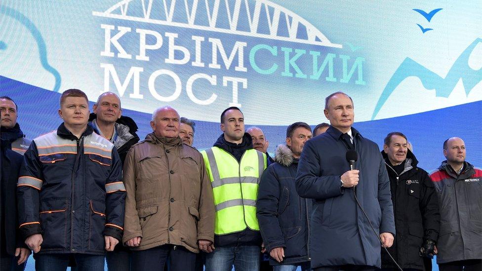 Russian President Vladimir Putin speaks to workers after riding a train connecting the Crimea to mainland Russia in Taman on December 23, 2019