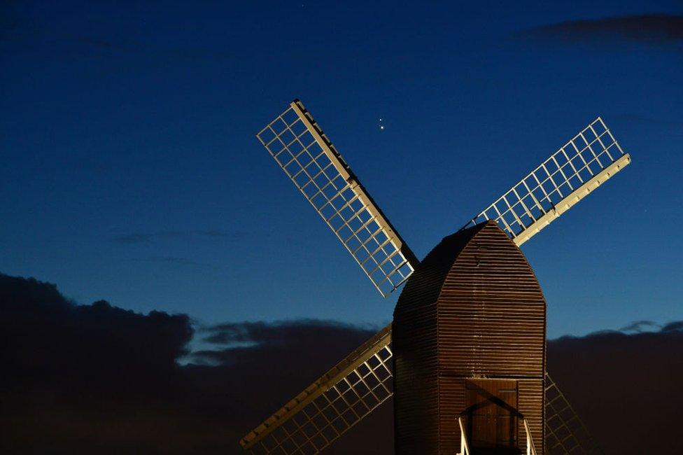 Jupiter and Saturn are seen coming together in the night sky, over the sails of Brill windmill, England. 20 December 2020